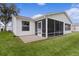 House exterior showcasing a screened patio and well-maintained lawn at 1309 Ballesteros Dr, The Villages, FL 32162