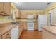 Bright kitchen with light wood cabinets, white appliances, and laminate flooring at 1309 Ballesteros Dr, The Villages, FL 32162