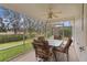 Relaxing screened porch with table and chairs, overlooking backyard at 1309 Ballesteros Dr, The Villages, FL 32162