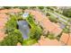 Aerial view of community featuring pond, pool, and buildings with tile roofs at 3036 Parkway Blvd # 206, Kissimmee, FL 34747