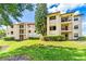 Exterior of two-story apartment building with red tile roofs and lush landscaping at 3036 Parkway Blvd # 206, Kissimmee, FL 34747