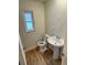 Updated bathroom with pedestal sink and wood-look flooring at 605 Aldama Ct, Ocoee, FL 34761