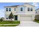 Two-story house with neutral siding, teal door and attached garage at 2204 Canyon Oak Dr, Davenport, FL 33837