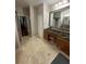 Bathroom with tiled floor, double sink vanity with granite countertop, and a large mirror at 113 Walton Heath Dr, Orlando, FL 32828