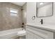 This bathroom has a tub and shower combination, modern fixtures, and a single sink vanity with quartz countertop at 27100 Racquet Cir, Leesburg, FL 34748
