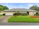 Charming single-story home with a well-manicured lawn, beautiful landscaping, and an attached two-car garage at 27100 Racquet Cir, Leesburg, FL 34748