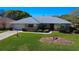 Charming single-story home featuring a manicured lawn, mature landscaping, and a welcoming facade at 27100 Racquet Cir, Leesburg, FL 34748