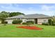 Charming single-story home with fresh landscaping, a well-manicured lawn, and a two-car garage at 27100 Racquet Cir, Leesburg, FL 34748
