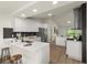 Modern kitchen boasts white cabinets, stainless steel appliances, quartz countertops, and sleek design at 27100 Racquet Cir, Leesburg, FL 34748