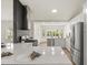 Modern kitchen with stainless steel appliances, white cabinets, quartz countertops, and a full backsplash at 27100 Racquet Cir, Leesburg, FL 34748