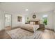 Spacious bedroom with natural light, wood-look floors, neutral decor, and an attached bathroom at 27100 Racquet Cir, Leesburg, FL 34748