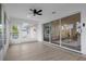 Bright sun room with ceiling fan and large sliding doors opening to living space at 27100 Racquet Cir, Leesburg, FL 34748