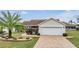 One-story house with a brick driveway and palm tree at 3096 Lansing Way, The Villages, FL 32162