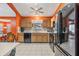 Bright kitchen with light wood cabinets, black appliances, and orange walls at 3096 Lansing Way, The Villages, FL 32162