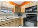 Kitchen corner with double sink, black appliances, and orange walls at 3096 Lansing Way, The Villages, FL 32162