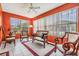 Relaxing sunroom with wood furniture and orange walls at 3096 Lansing Way, The Villages, FL 32162