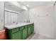 Green vanity with double sinks, and a shower with white curtains at 8638 Triumph Cir, Wildwood, FL 34785