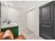 Bathroom with green vanity, double sinks, and a shower at 8638 Triumph Cir, Wildwood, FL 34785