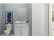 Clean bathroom with white vanity, a large mirror, and blue walls at 2031 Stake Out Way, Apopka, FL 32703