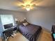 Well-lit bedroom featuring a ceiling fan, a large window, and a desk at 2157 Geneva Dr, Lakeland, FL 33805