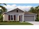 Attractive one-story house with a two-car garage and landscaped lawn at 251 Puma Loop, Groveland, FL 34736