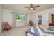 Cozy bedroom with a queen-size bed, ceiling fan, and ample natural light at 10984 Sw 81St Ave, Ocala, FL 34481