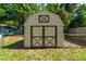 Tan gable-style storage shed in the backyard at 5018 Se 106Th Pl, Belleview, FL 34420