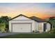 One-story house with two-car garage, light-colored walls, and a dark brown roof at 5879 Sw 87Th Ave, Ocala, FL 34481