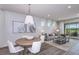 Bright dining room with wood table, white chairs, and access to the backyard at 5903 Sw 87Th Ave, Ocala, FL 34481