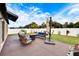 Spacious backyard patio with seating area, fire pit, and umbrella at 2954 Flying Blackbird Rd, Bartow, FL 33830