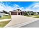 Two-car garage home with a long driveway and landscaping at 2954 Flying Blackbird Rd, Bartow, FL 33830