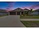 Two-car garage home with landscaping at sunset at 2954 Flying Blackbird Rd, Bartow, FL 33830