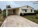 Front view of a yellow house with a carport and landscaping at 3109 Sand Trap Ct, Lakeland, FL 33810