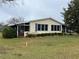 House exterior features light yellow siding and lush landscaping at 3109 Sand Trap Ct, Lakeland, FL 33810