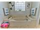 Bathroom with jetted tub, double vanities, and large window at 706 Lake Diamond Ave, Ocala, FL 34472