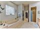 Large Primary bathroom with soaking tub, shower, and walk-in closet at 706 Lake Diamond Ave, Ocala, FL 34472
