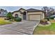 Tan one-story house with landscaped yard, attached garage, and driveway at 706 Lake Diamond Ave, Ocala, FL 34472