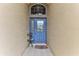 Blue front door with glass accents, a welcome mat and small side table at 706 Lake Diamond Ave, Ocala, FL 34472