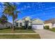 Single-story house with green exterior, palm tree, and two-car garage at 2254 Wyndham Palms Way, Kissimmee, FL 34747