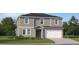 Two-story house with gray siding, white garage door, and landscaping at 692 Bald Cypress Dr, Lakeland, FL 33801