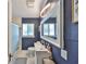 Modern bathroom features blue walls, large mirror, white marble floors and modern fixtures at 1412 E Main St, Lakeland, FL 33801