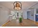 Open-concept dining room showcasing a modern light fixture, wood floors, and an inviting view into the kitchen at 1412 E Main St, Lakeland, FL 33801