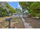 Quaint one-story home with a grey exterior, a well-manicured lawn, and charming front yard foliage at 1412 E Main St, Lakeland, FL 33801