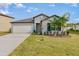 House exterior featuring a two-car garage and landscaping at 2133 Old Mining Rd, Lakeland, FL 33801