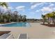 The pool shows clear water, palm trees, lounge chairs, and a brick paver deck on a sunny day at 2133 Old Mining Rd, Lakeland, FL 33801