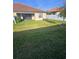 Large backyard with lush green grass, a privacy fence, and a covered patio at 4035 Solamor St, Lakeland, FL 33810