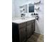 Bathroom vanity featuring a marble countertop, dark cabinetry, and rustic wood shelves at 4035 Solamor St, Lakeland, FL 33810