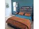 Bedroom with teal walls, wooden bed frame, and brown bedding at 4035 Solamor St, Lakeland, FL 33810