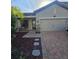 Home boasts a brick driveway, manicured landscaping, and a convenient two-car garage at 4035 Solamor St, Lakeland, FL 33810
