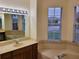 Primary bathroom with double sinks, garden tub, and window at 2912 Sweetspire Cir, Kissimmee, FL 34746